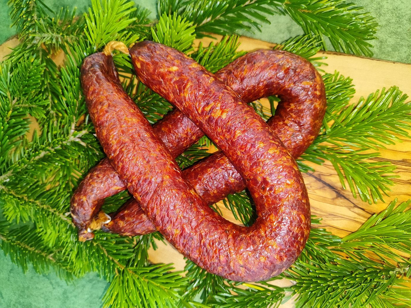 Wildbratwurst-Ringe frisch präsentiert vor Tannengrün